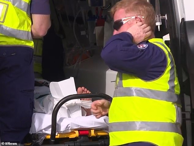 Incredibly, the car missed the stroller by inches and the baby was unharmed, but the woman fell to the ground with a broken leg (she is pictured in an ambulance)