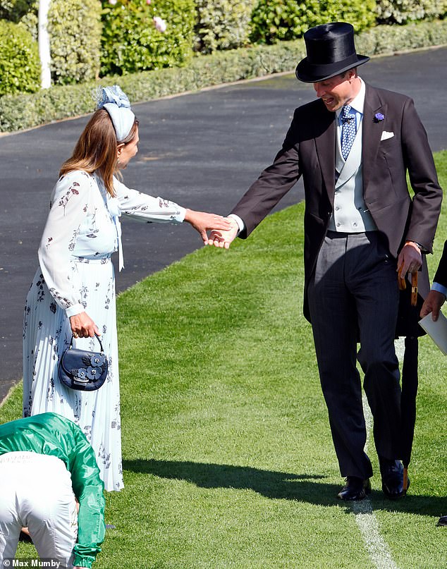 Carole Middleton grabs son-in-law Prince William's hand as her heel gets stuck in the grass at Royal Ascot yesterday