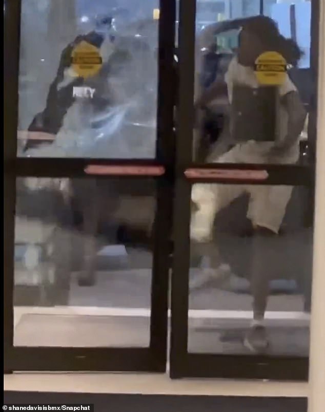 A man was seen kicking open the glass doors of a hotel after struggling to get inside