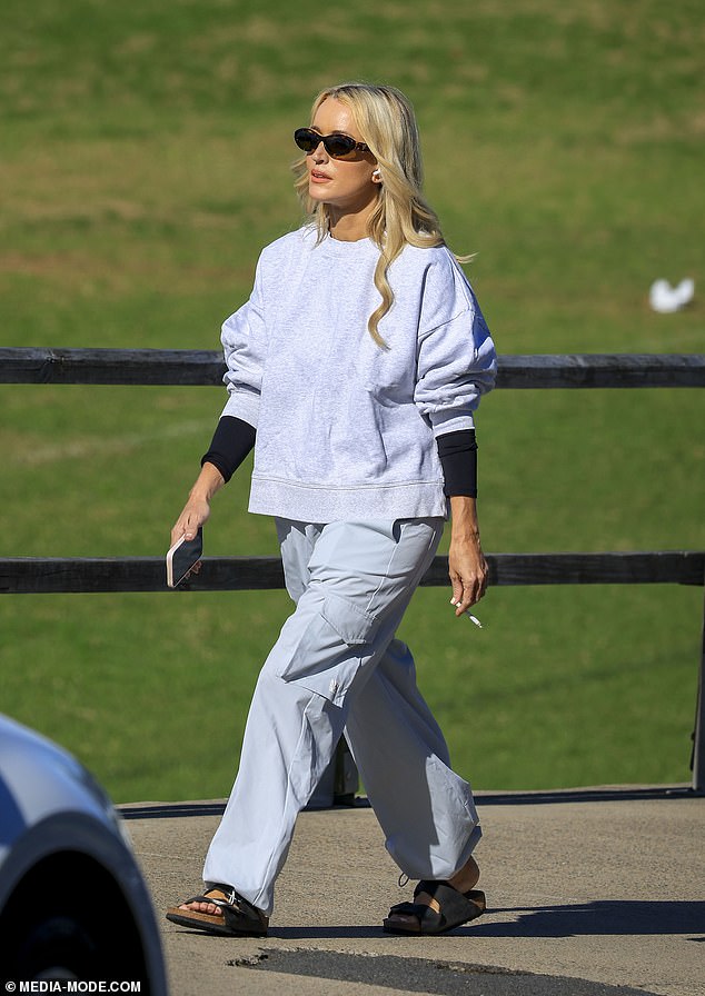 Jackie 'O' Henderson, 49, (pictured) looked completely carefree on Monday as she was spotted walking along the water near her home in Clovelly