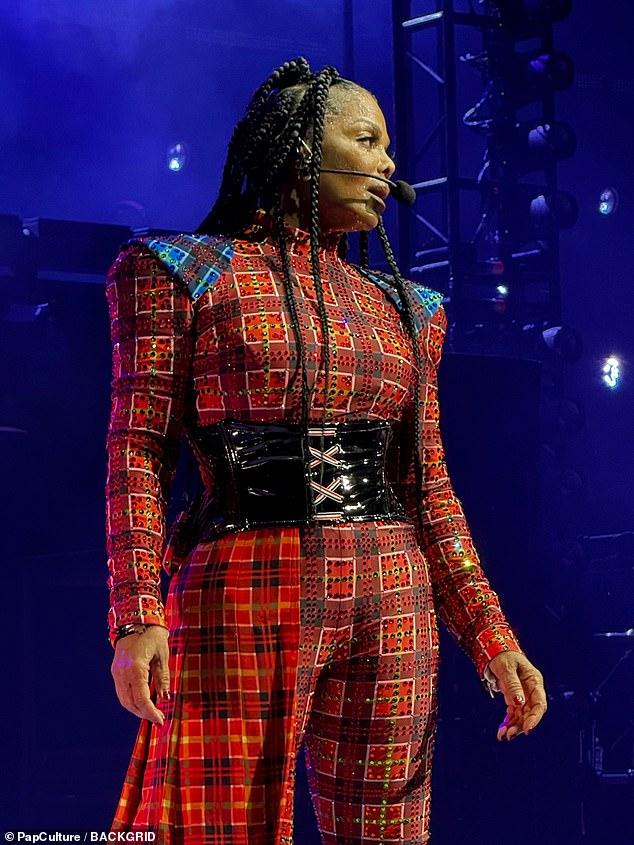 In an outfit change, the pop icon once again appeared in a red plaid jumpsuit with a black patent leather corset-style belt that added definition to her waist