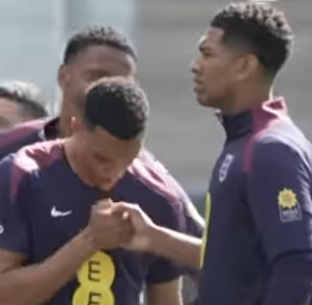 Bellingham and Alexander-Arnold were perfecting a new handshake during training, while Ezri Konsa watched in the background