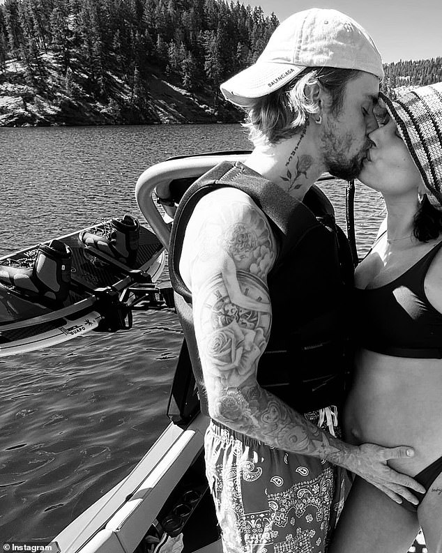 Justin Bieber gave fans another glimpse of his wife Hailey Bieber's growing baby bump when he shared photos from their recent sun-soaked lake vacation