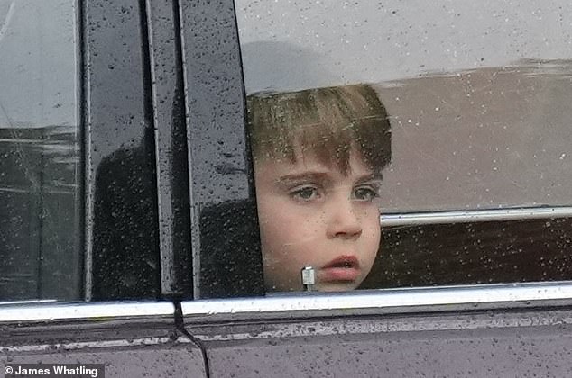 Prince Louis looks out the car window as the family enters Buckingham Palace today
