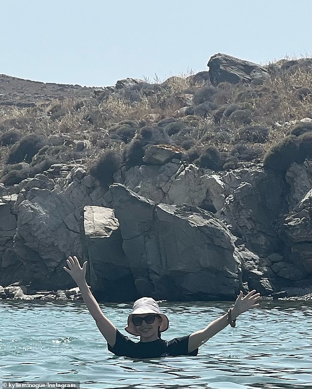 Kylie Minogue shared a series of photos from her holiday in Greece to Instagram on Thursday, including a photo of herself swimming in a black rash vest