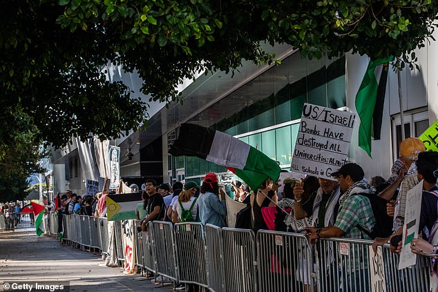 Pro-Palestinian demonstrators stand in front of the entrance to the theater