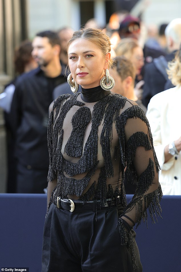 Looking the epitome of elegance, she showed off flashes of skin through a sheer high-neck, long-sleeved top with sparkling black and silver tassels.