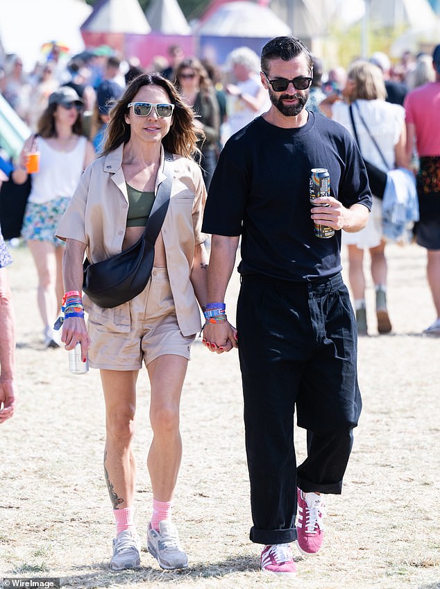 Mel C couldn't contain her smile as she walked through the Glastonbury Festival hand-in-hand with a mystery man on Saturday