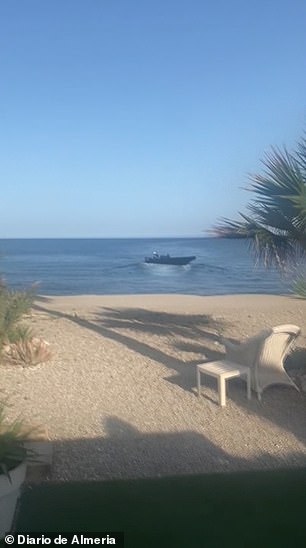 The boat that brought migrants to shore is then seen sailing away at high speed