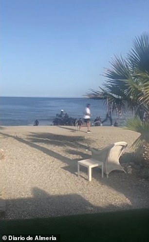 A bewildered jogger could be seen running past the boat as it landed on the sandy stretch of coastline in southern Spain