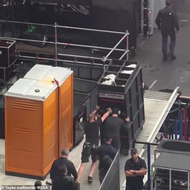 Two handsome security guards have been filmed pushing the 6ft container as Lady Gaga's song Applause fills the stadium