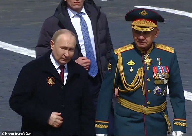 Putin plays with his jacket and moves awkwardly during the May 9 celebrations on Red Square, together with ex-Defense Minister Sergei Shoigu