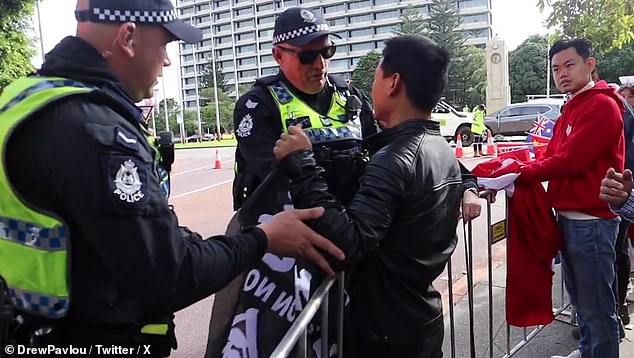 Footage of police targeting a lone Tibetan protester after he waved the Free Hong Kong flag at Prime Minister Li Qiang's motorcade has sparked outrage online (pictured)