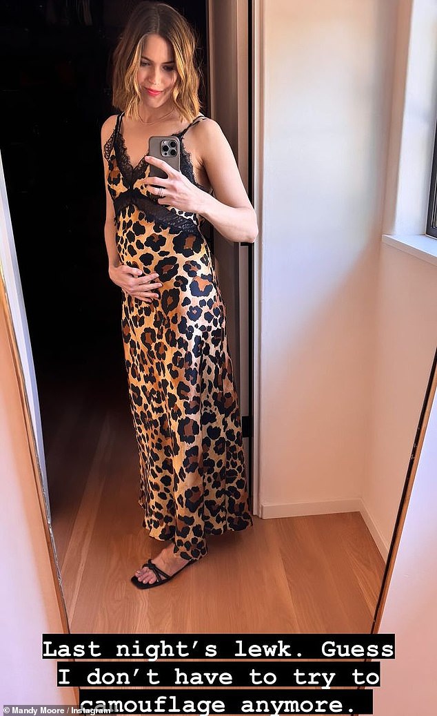 Mandy Moore cradled her burgeoning bump in a photo she posted on Saturday - a day after making her pregnancy public