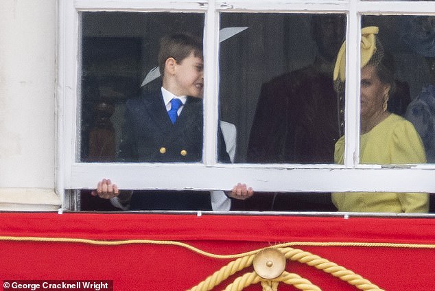 Prince Louis tries to open a window on a balcony of the Horse Guards Parade next to the Duchess of Edinburgh