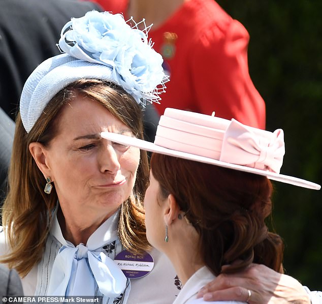 Carole Middleton lovingly put her arm around Eugenie, who wore her hair up, revealing her unusual tattoo