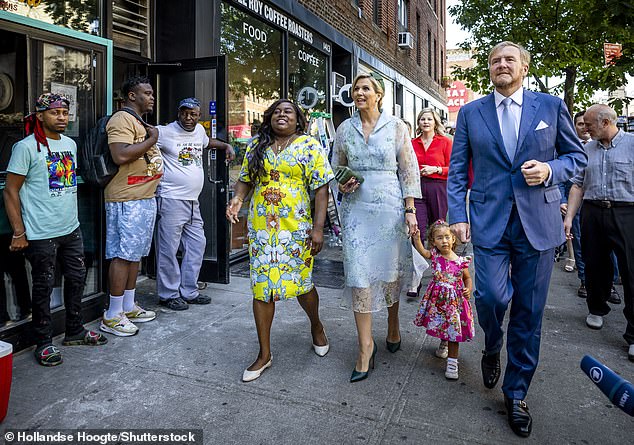 The Dutch royal couple were pictured strolling through the neighborhood with local residents dressed in equally colorful attire