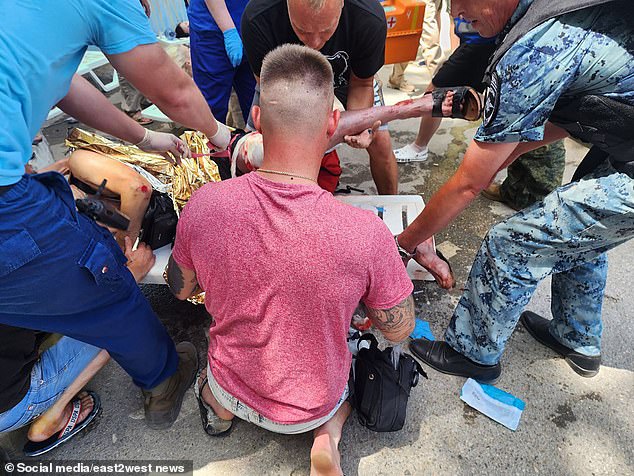 People gather around a Russian tourist injured by the downed Ukrainian missile in Crimea on Sunday