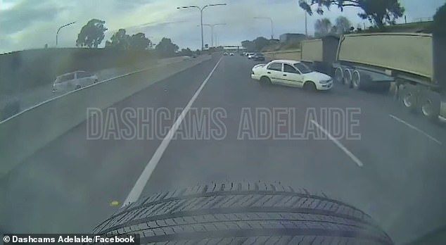 Shocking dashcam footage has emerged showing a car veering across a highway and narrowly avoiding the wheels of a large truck