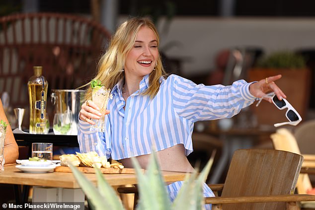 Sophie Turner, 28, showed off her toned torso in a chic striped co-ord set as she sipped a cocktail during an al fresco lunch in the south of France on Friday