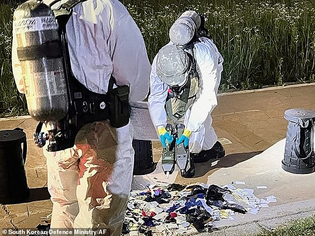 Staff in hazmat suits were seen collecting piles of rubbish containing everything from cigarette butts to bits of cardboard and plastic