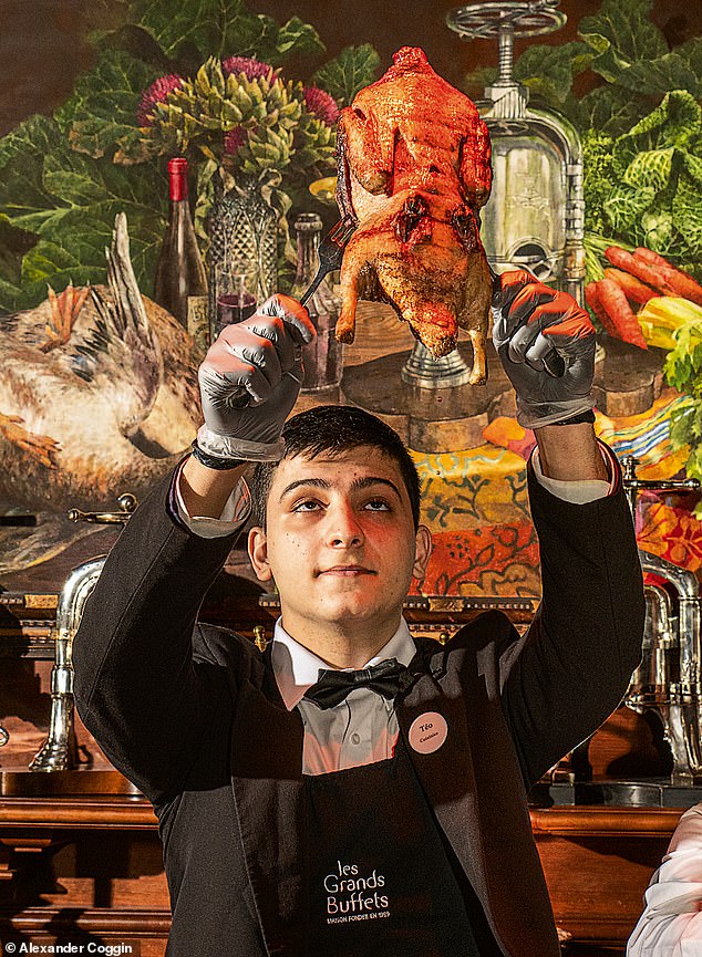 One of the waiters holds up a canard au sang, or pressed duck