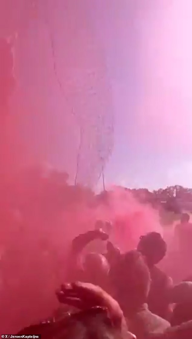 Fans were engulfed in a cloud of red smoke as they fired flares and watched players walk onto the field