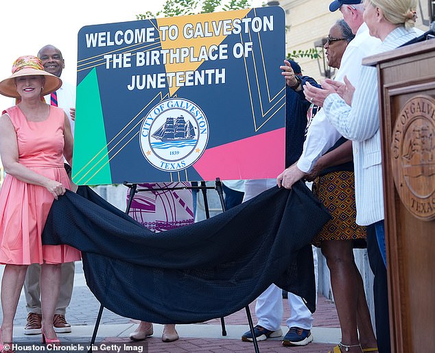 Members of the City of Galveston government unveil new signage that will be installed on the highway entering the island to recognize the place as the birthplace of Juneteenth