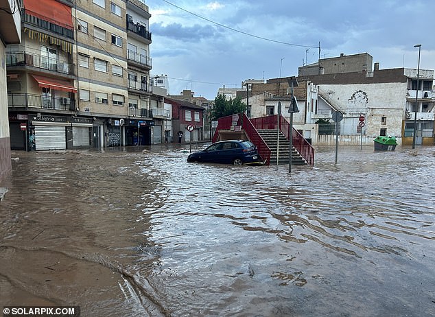 Several regions in southeastern Spain have been hit by torrential rain, hail and strong winds, causing flash floods and forcing road closures.  In the photo: a car can be seen half submerged in the water of the city of Murcia