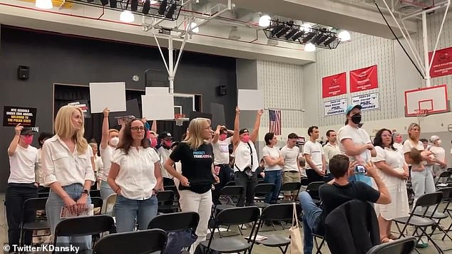 Trans activists in matching outfits hum loudly to drown out speakers they disagree with during a Manhattan school board meeting on Wednesday