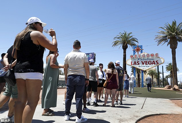 People drink water while visiting the iconic Welcome to the Fabulous Las Vegas sign on June 6.  Temperatures are expected to reach 100 degrees as Trump holds a rally in the city on Sunday
