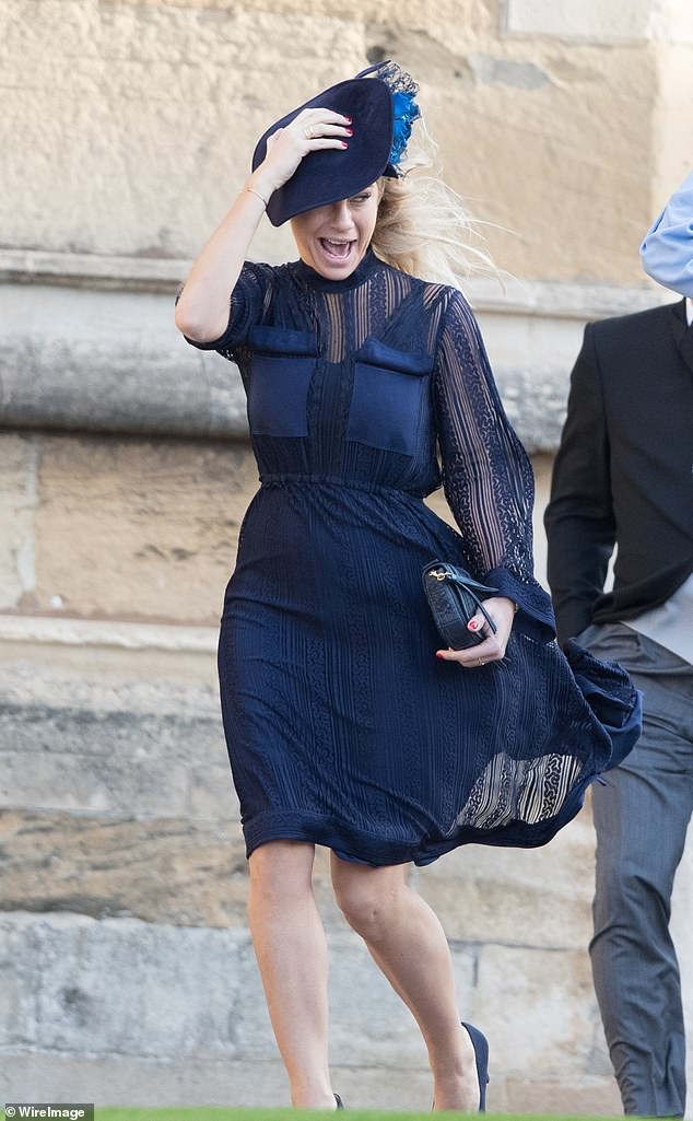 Chelsy Davy screams in the stormy weather as she arrives at St George's Chapel for the wedding of Princess Eugenie and Jack Brooksbank
