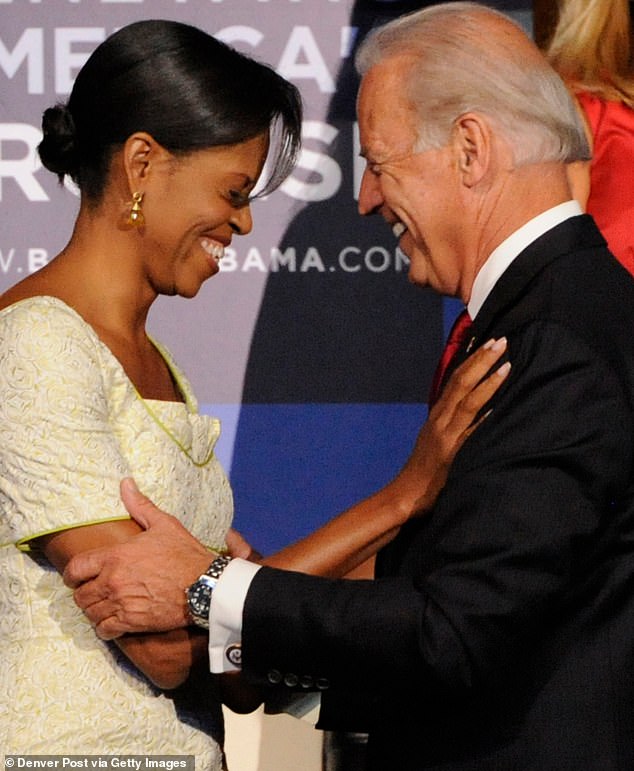 Michelle Obama is greeted by Senator Joe Biden in the stands of the Pepsi Center during the second day of the Democratic National Convention on Tuesday, August 26, 2008 in Denver, Colorado