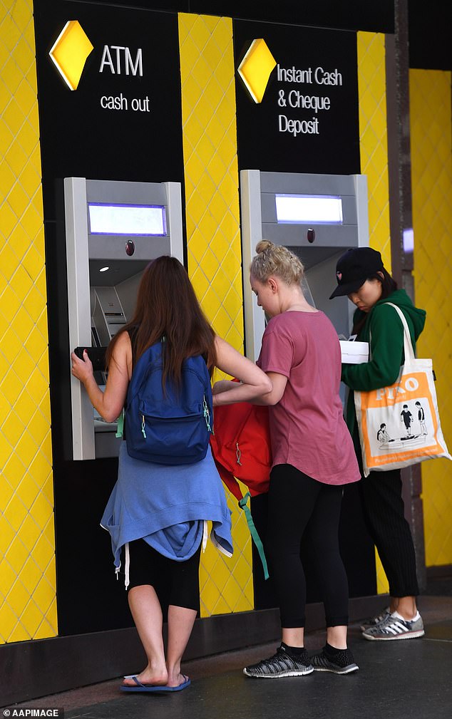 Commonwealth Bank (CBA) has reduced the maximum amount customers can deposit into their accounts from $1,000 to $750 per day (Photo: People in Brisbane using ATMs)