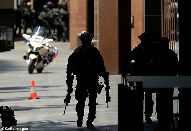 The officer who saved lives by taking down an Islamist terrorist nearly a decade ago still cannot be named for legal reasons and he desperately wants his name back.  A heavily armed police officer is pictured at the scene on December 15, 2014