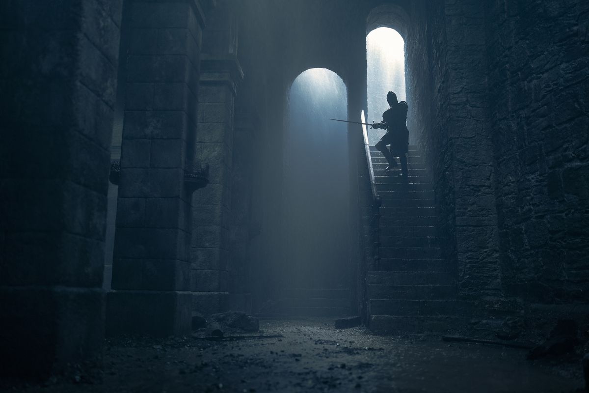 Daemon (Matt Smith) walks down the stairs in Harrenhal with his sword in House of the Dragon season 2
