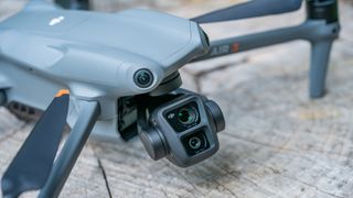 DJI Air 3 drone on a tree stump with close-up of the dual cameras