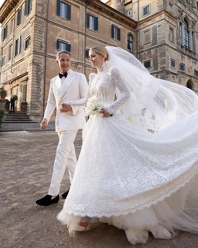 For her main wedding dress, Kitty opted for a Victorian-inspired white lace gown with a high neckline, feminine puff sleeves and a cinched waist