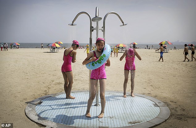 North Korean girls in similar swimsuits stand under a shower at the Songdowon International Children's Camp, Tuesday, July 29, 2014, in Wonsan, North Korea