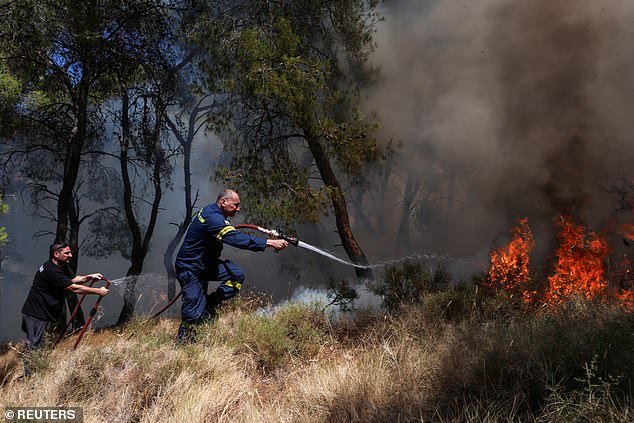 KERATEA -- A firefighter works to extinguish a burning forest fire