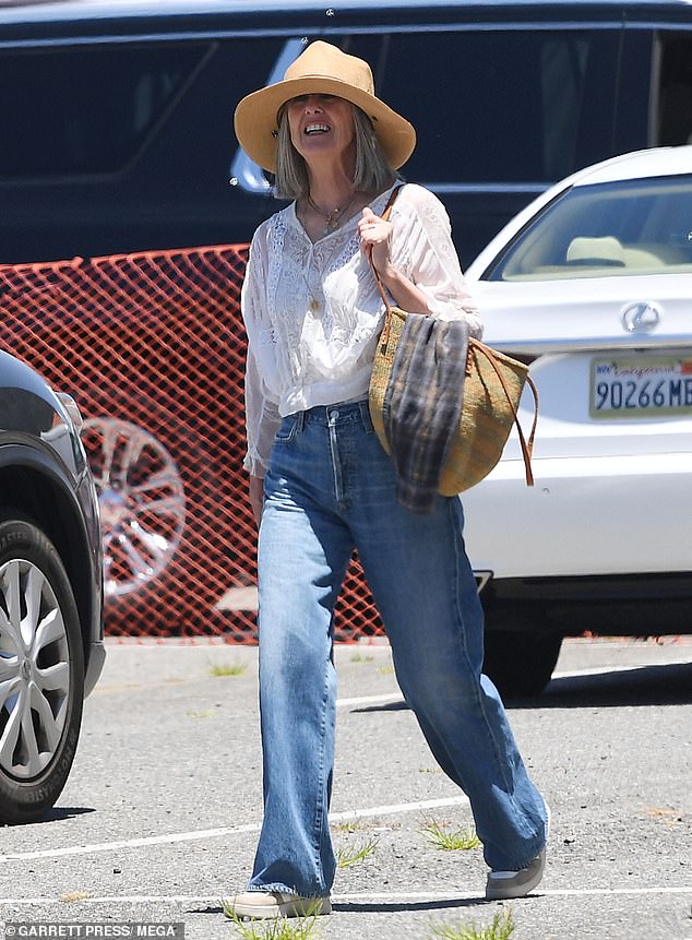 The Mork & Mindy star wore a white blouse, high-waisted jeans and a straw hat to cover her short gray hair