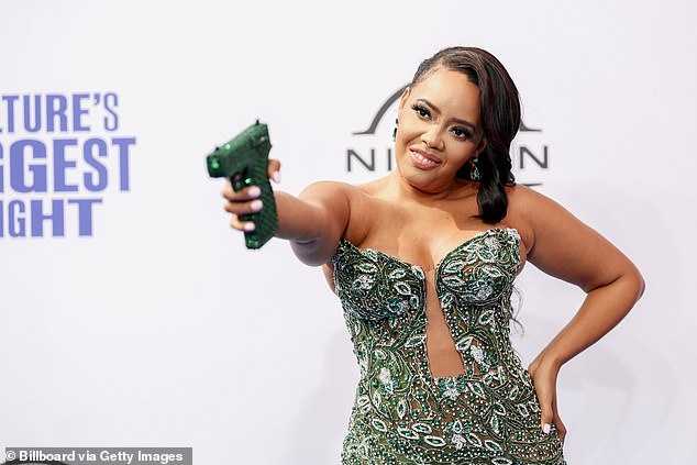 On the red carpet, Simmons boldly posed with the bag in the shape of a gun, even pointing it as if she was about to pull the trigger