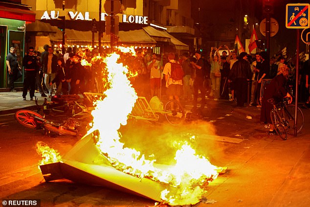 A barricade is set on fire as protesters protest against the National Struggle Party