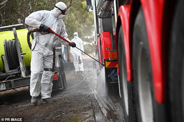 Workers in protective suits clean a truck in a quarantine area following a bird flu outbreak in Victoria