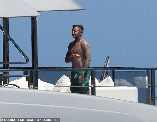 David showed off his tattooed body as he soaked up the sun in Sardinia