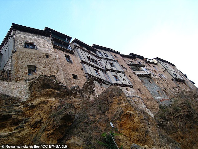 The photo shows striking houses hanging from vertical rock faces. Photo courtesy of Creative Commons