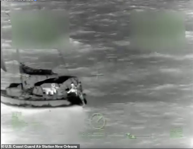 A Coast Guard rescuer is seen aboard the sunken vessel