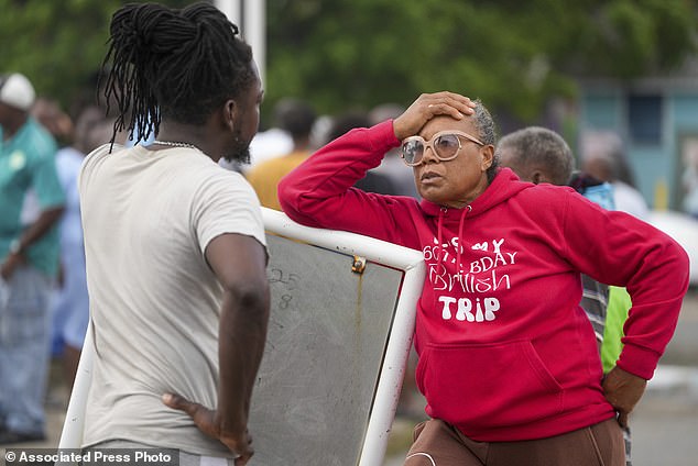 Sylvia Small, right, waits for permission from police to enter the pier to inspect damage to her boat caused by Hurricane Beryl at Bridgetown Fisheries in Barbados, Monday, July 1, 2024.