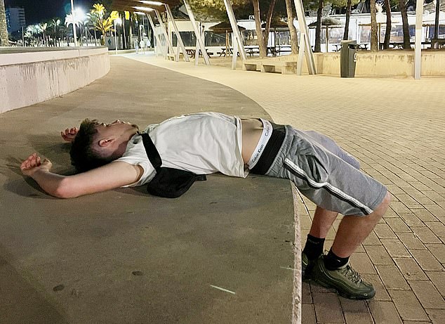 Pictured: A partygoer is seen unconscious on a step on the strip