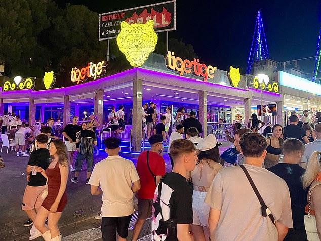 Pictured: Large groups of revellers gather in the streets of Magaluf after the shocking incidents